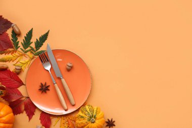 Taze balkabakları, meşe palamutları, yıldız anasonu ve turuncu arka planda sonbahar yapraklarıyla güzel bir masa.