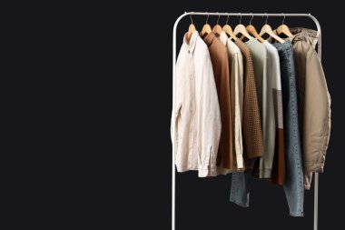 Siyah arka planda erkek kıyafetleriyle dizilin.