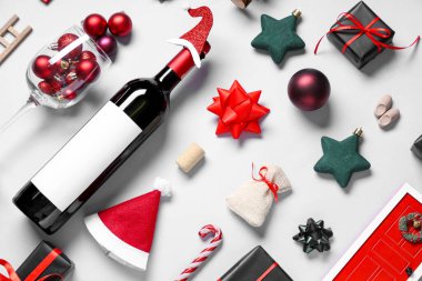 Beyaz arka planda şarap şişesi ve Noel süslemeleri olan kompozisyon
