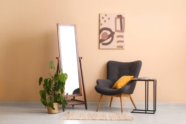 Koltuk, sehpa ve ayna oturma odasının içinde.