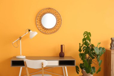 Çalışma odasının içinde lamba ve ayna olan bir yer.