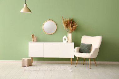 Koltuk, çekmece sandığı ve oturma odasının içindeki ayna.