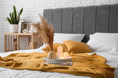 Modern yatak odasının içi yanan mumlarla dolu.