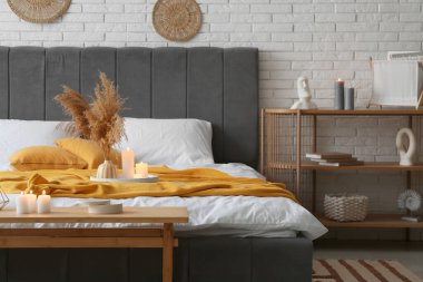 İçinde yanan mumlar olan şık bir yatak odası.