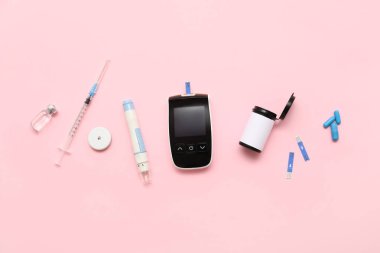 Kalemli glukometre, glukoz sensörü ve pembe arka planda insülin. Diyabet kavramı