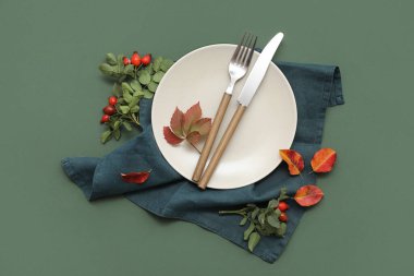 Yeşil arka planda gül kalçası böğürtlenleri ve sonbahar yapraklarıyla güzel bir masa.