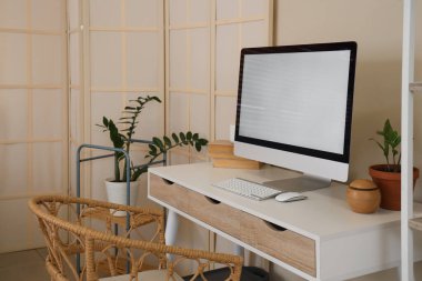 Oturma odasının içinde programcı masası olan şık bir iş yeri.