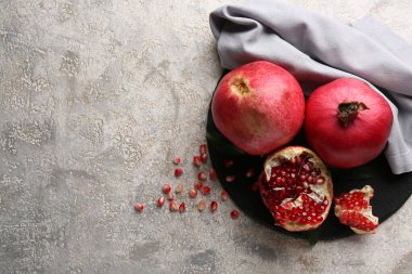 Taze olgun narı ve gri arka planda tohumları olan siyah tahta.