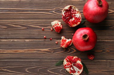 Tahta zemin üzerinde tohum ve yapraklarla taze olgun narlar.