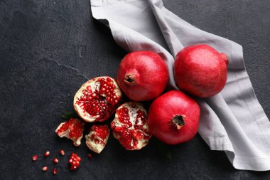 Koyu arkaplanda tohumları olan taze olgun narlar.