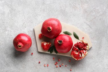 Taze olgun narı ve gri arka planda tohumları olan tahta.