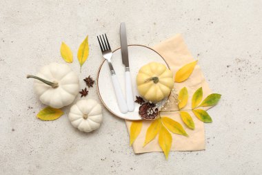 Sonbahar yaprakları, yıldız anasonu ve beyaz arka planda taze balkabaklarıyla güzel bir masa.