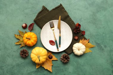 Güz yaprakları, kestaneler, çam kozalakları ve yeşil arka planda taze balkabaklarıyla güzel bir masa.