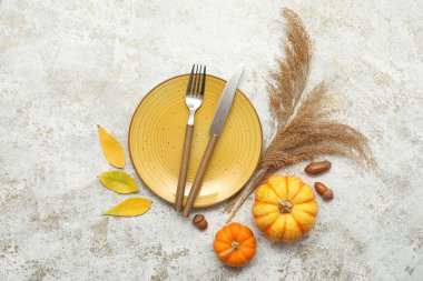 Güz yaprakları, meşe palamutları ve beyaz arka planda taze balkabaklarıyla güzel bir masa.