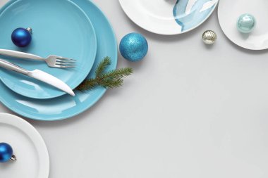 Gri arka planda Noel topları ve köknar dallarıyla güzel bir masa.