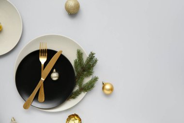 Gri arka planda Noel topları ve köknar dallarıyla güzel bir masa.