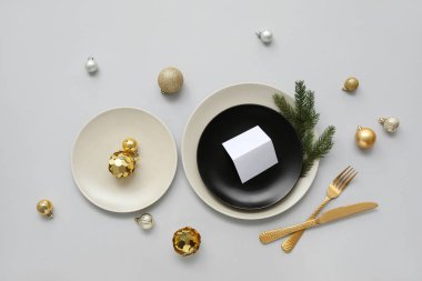 Gri arka planda Noel topları ve köknar dallarıyla güzel bir masa.