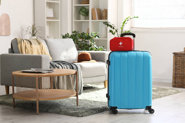 Чемодан с аптечкой на полу в номере