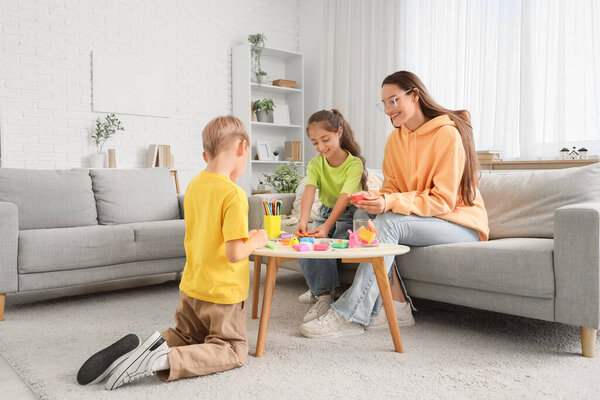 Маленькие дети со своей матерью делают скульптуры из пластилина дома