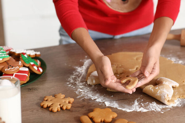 Молодая женщина делает пряничное печенье на кухне в канун Рождества, крупным планом