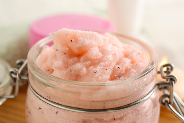 Jar of natural body scrub on light background, closeup