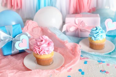 Beyaz grunge masasında hediye kutuları ve süslemeleri olan lezzetli kekler. Cinsiyet ortaya çıkan parti kavramı