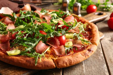 Tahta arka planda domatesli ve roka aromalı lezzetli pizzalar.