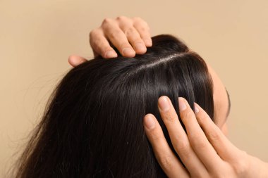 Bej arka planda kepekli genç kadın, yakın plan.