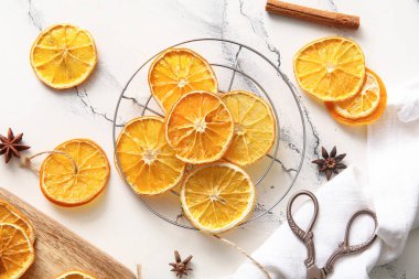 Kurumuş portakal dilimleri ve beyaz arka planda yıldız anason ile durun.