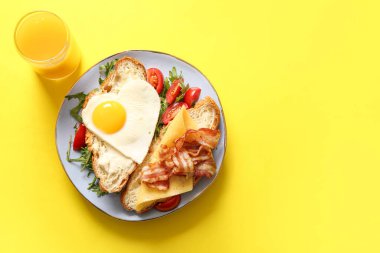 Lezzetli kızarmış yumurta, kruvasan, pastırma, domates ve roka.