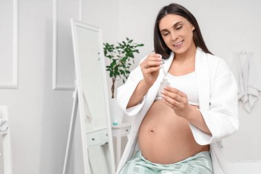 Banyoda serumu olan hamile bir kadın.