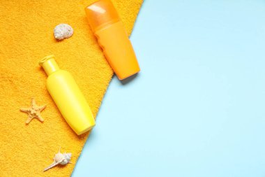 Renkli arkaplanda güneş kremi, havlu ve deniz kabuğu şişeleri olan kompozisyon