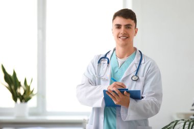 Klinikte panosu olan genç bir doktor.