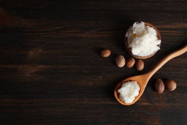 Koyu ahşap arka planda Shea yağı ve fındık