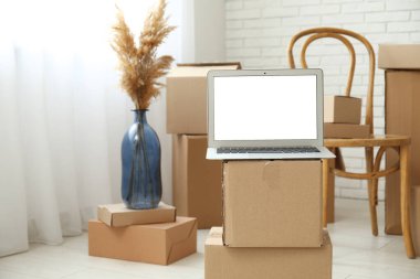 Işık odasındaki kutuları taşıyan boş dizüstü bilgisayar, kapat