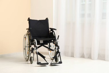 Odanın penceresinin yanındaki boş tekerlekli sandalye.