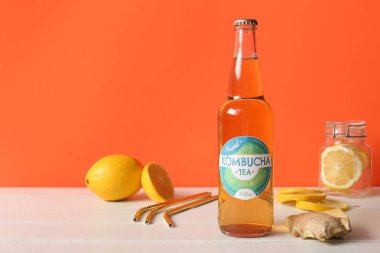 Beyaz ahşap masada limonlu ve zencefilli bir şişe lezzetli kombu çayı.