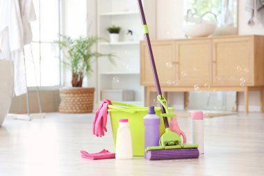 Evde kovayla paspas ve farklı temizlik malzemeleri var.