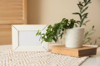Boş çerçeve, kitap ve bitki yemek masasında, yakın plan.