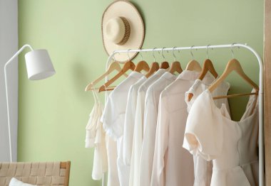 Yeşil duvarın yanındaki beyaz elbiseli rafta.