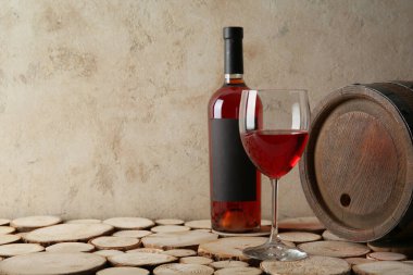 Fıçı, şişe ve kırmızı şarap ahşap masada grunge bej arka planda