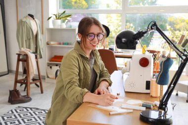 Stüdyoda çalışan kadın moda tasarımcısı.