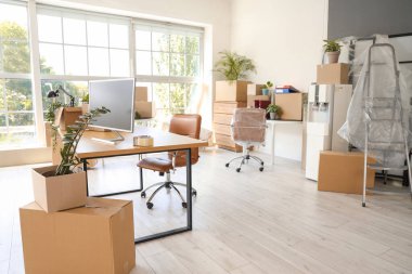 Taşınma gününde içinde çiçekler ve kutular olan masalar