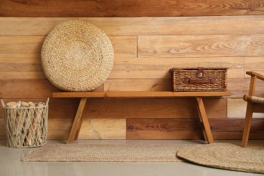 Hasır kutulu bank ve odasındaki tahta duvarın yanında puf.