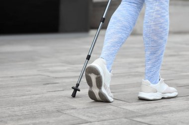 Sportif kadın İskandinav yürüyüşü yapıyor.