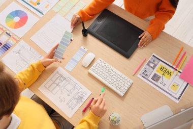 Ofisteki masada çalışan birkaç grafik tasarımcısı, üst görünüm