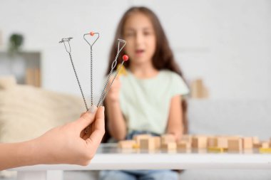 Ofisteki küçük kıza karşı logopedik araştırma yapan kadın konuşma terapisti.