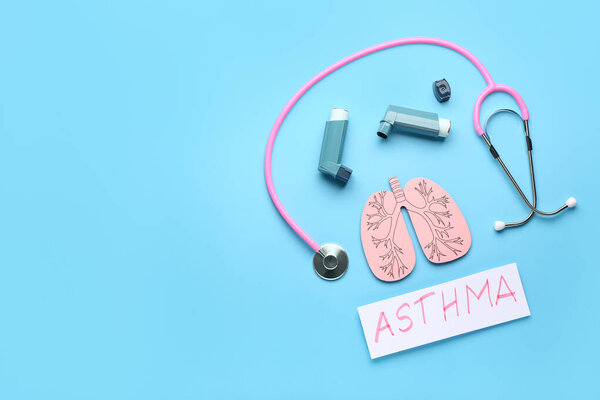 Состав с ингаляторами, бумажными легкими, стетоскопом и листом бумаги с текстом ASTHMA на синем фоне