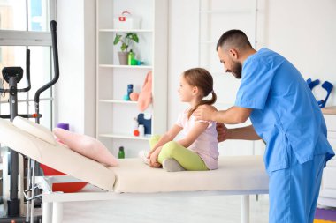 Rehabilitasyon merkezinde küçük bir kızla çalışan fizyoterapist.