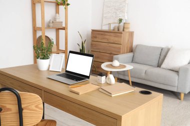 Oturma odasındaki programcının masasına çerçeveli boş bir dizüstü bilgisayar.